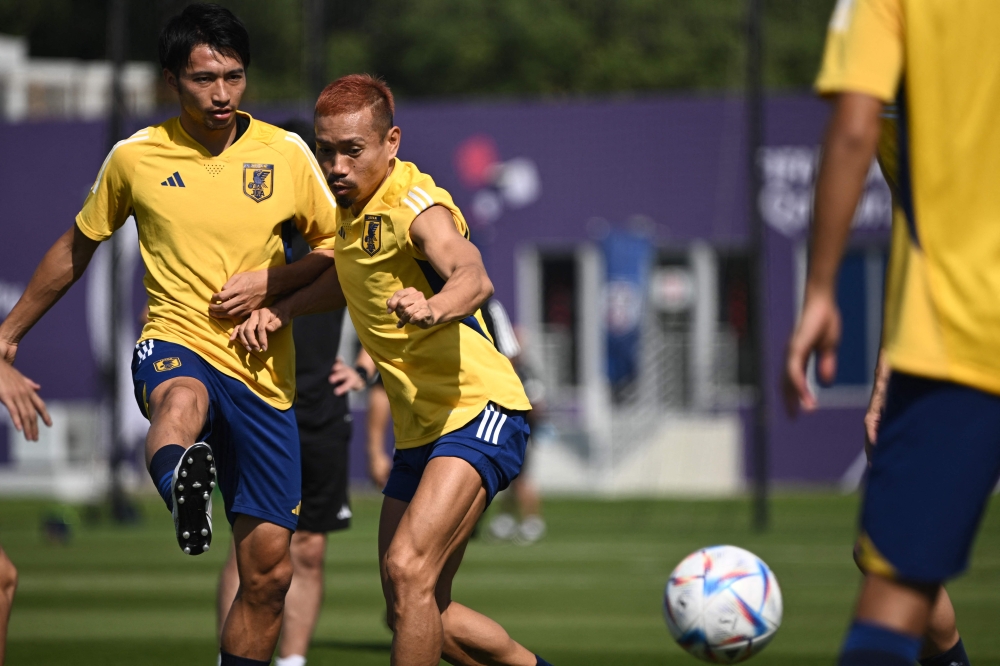 Japan's defender Yuto Nagatomo (right) along with his teammate takes part in a training session at Al Sadd SC in Doha on November 26, 2022, on the eve of the Qatar 2022 World Cup football match between Japan and Costa Rica. (Photo by Philip FONG / AFP)