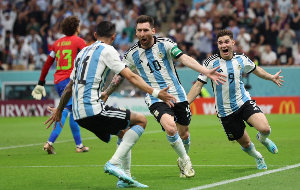 Argentina's Lionel Messi celebrates scoring their first goal against Mexico with Julian Alvarez and Angel Di Maria at the Lusail Stadium in Lusail, Qatar, on November 26, 2022. REUTERS/Pedro Nunes.