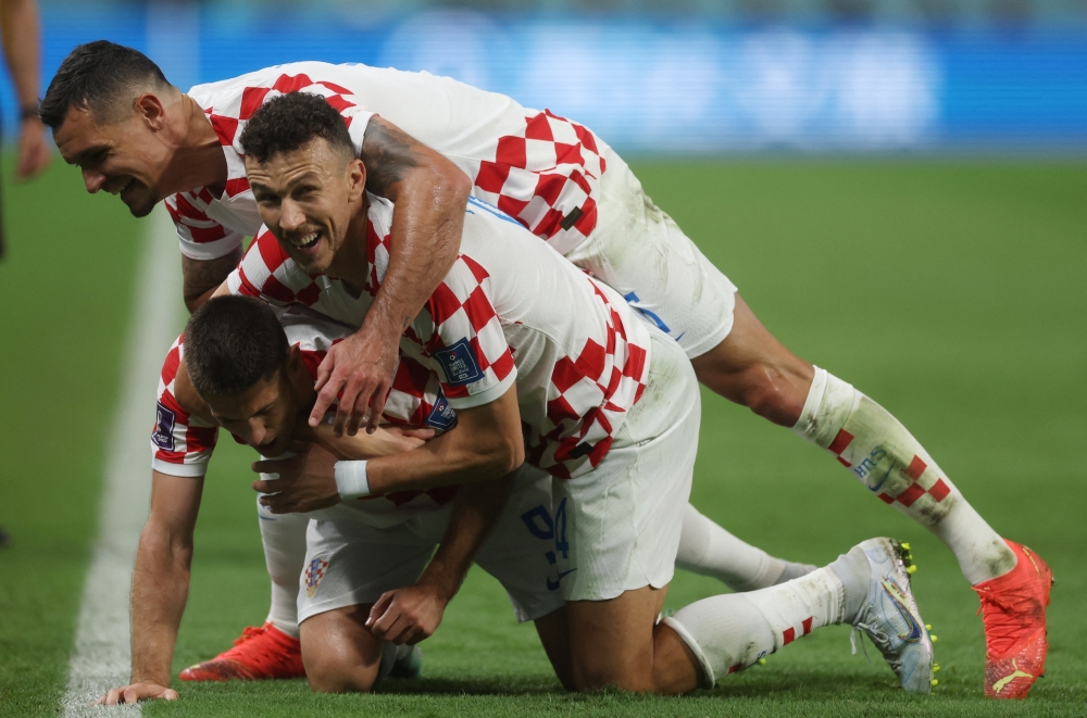 Croatia's Andrej Kramaric celebrates scoring their third goal of the FIFA World Cup Qatar 2022 Group F match against Canada with teammates Ivan Perisic and Dejan Lovren at the Khalifa International Stadium, Doha, Qatar, on November 27, 2022.  REUTERS/Paul Childs