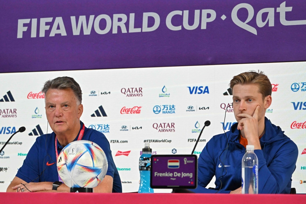 Netherlands' coach Louis Van Gaal (left) and midfielder Frenkie De Jong attend a press conference at the Qatar National Convention Center (QNCC) in Doha on November 28, 2022, on the eve of the Qatar 2022 World Cup football match between the Netherlands and Qatar. (Photo by Alberto PIZZOLI / AFP)