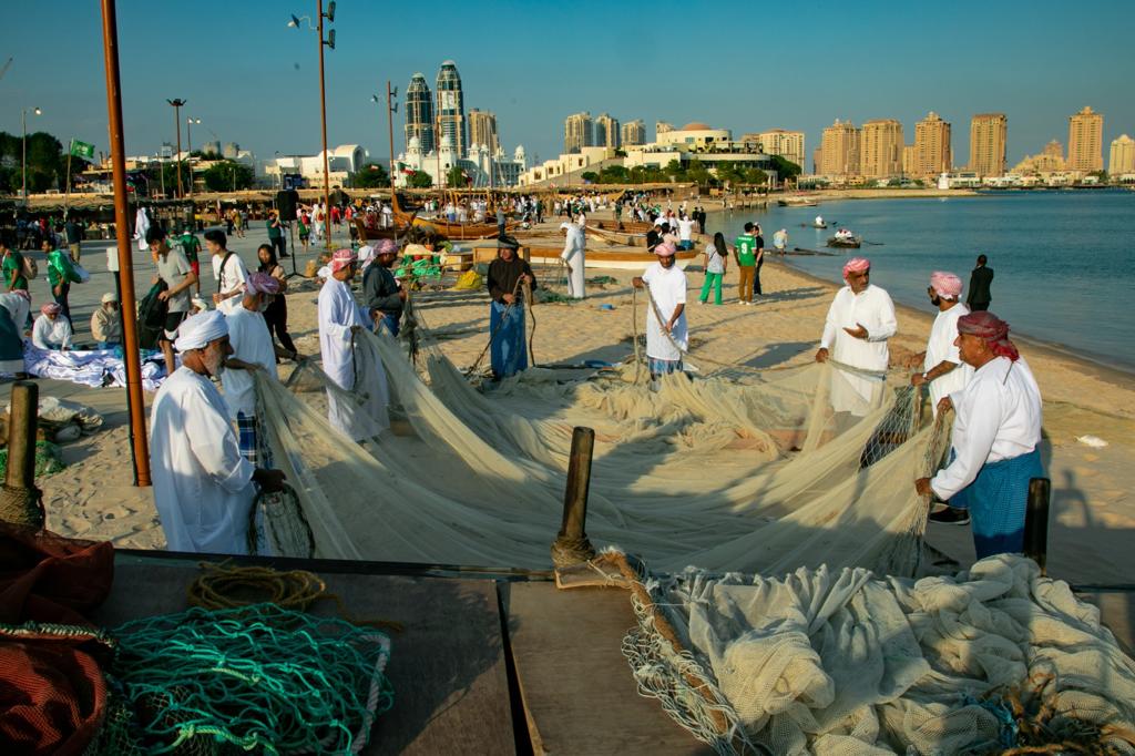 Participants prepare fishing nets during the Traditional Dhow Festival at Katara beach.