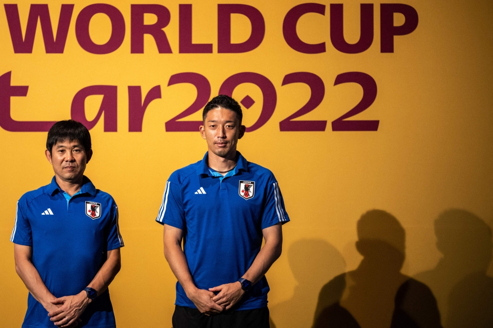 Japan's coach Hajime Moriyasu (left) and Japan's goalkeeper Shuichi Gonda pose on the green carpet ahead a press conference at the Qatar National Convention Center (QNCC) in Doha on November 30, 2022, on the eve of the Qatar 2022 World Cup football match between Japan and Spain. (Photo by Philip FONG / AFP)
 