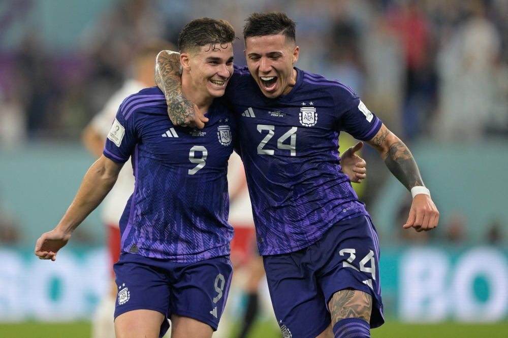 Argentina's forward #09 Julian Alvarez (L) celebrates with Argentina's midfielder #24 Enzo Fernandez after he scored his team's second goal during the Qatar 2022 World Cup Group C football match between Poland and Argentina at Stadium 974 in Doha on November 30, 2022. (Photo by JUAN MABROMATA / AFP)