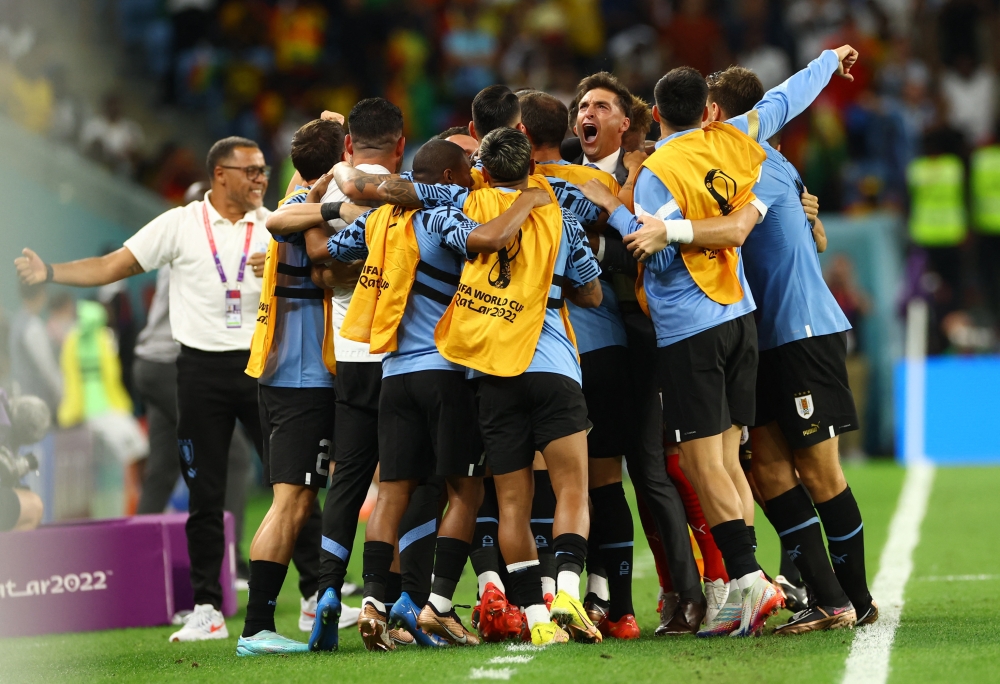 Uruguay's Giorgian de Arrascaeta celebrates scoring their first goal with coach Diego Alonso and teammates during the Qatar World Cup final Group H match between Ghana and Uruguay at the Al Janoub Stadium on December 2, 2022. (REUTERS/Bernadett Szabo)

