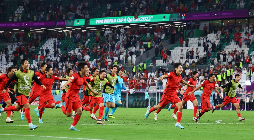 South Korea players celebrate after the match as South Korea qualify for the knockout stages during the Qatar World Cup final Group H match between Korea and Portugal at the Education City Stadium on December 2, 2022. (REUTERS/Wolfgang Rattay)