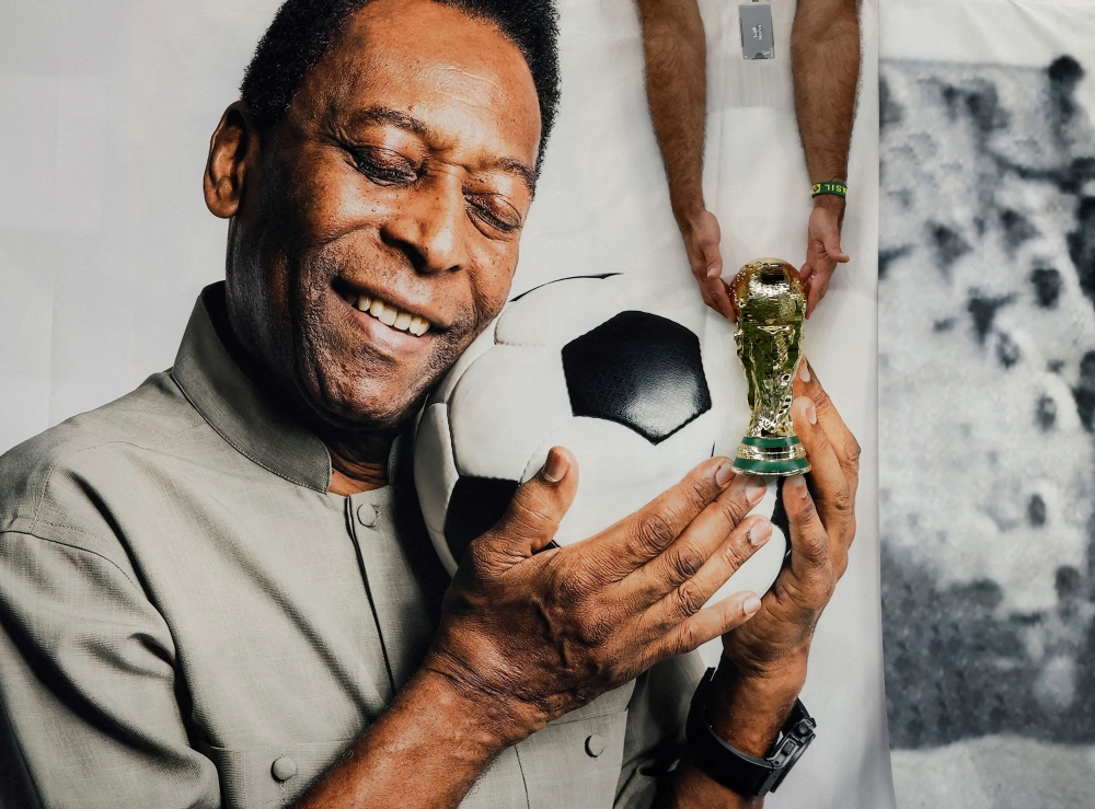 Brazil fan holds a replica World Cup trophy in front of a banner of former Brazil player Pele before the Cameroon v Brazil match at Lusail Stadium, Lusail, Qatar - December 2, 2022 REUTERS/Benoit Tessier/File Photo