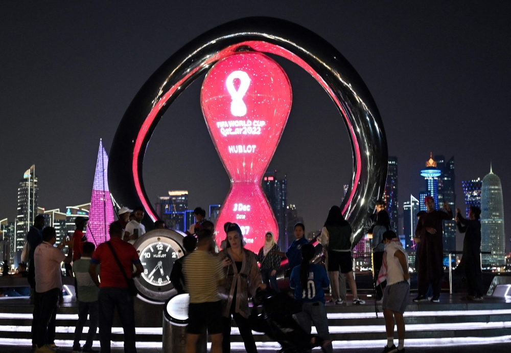 People take pictures in front of the Fifa countdown clock at the Corniche promenade in Doha on December 3, 2022, during the Qatar 2022 World Cup football tournament. (Photo by Jung Yeon-je / AFP)