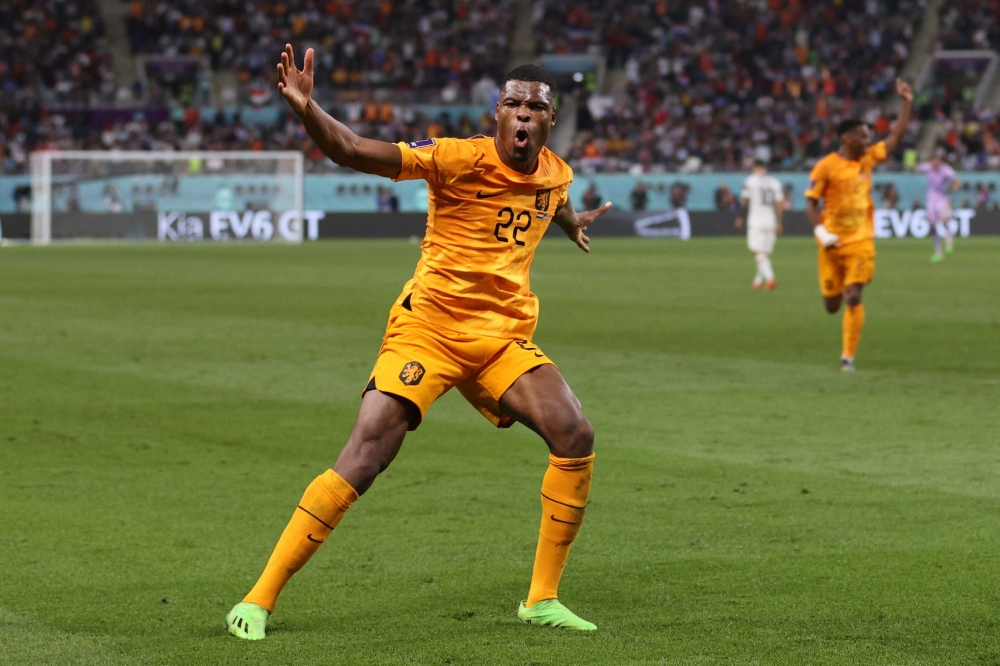 Netherlands' defender #22 Denzel Dumfries celebrates scoring his team's third goal during the Qatar 2022 World Cup round of 16 football match between the Netherlands and USA at Khalifa International Stadium in Doha on December 3, 2022. (Photo by ADRIAN DENNIS / AFP)