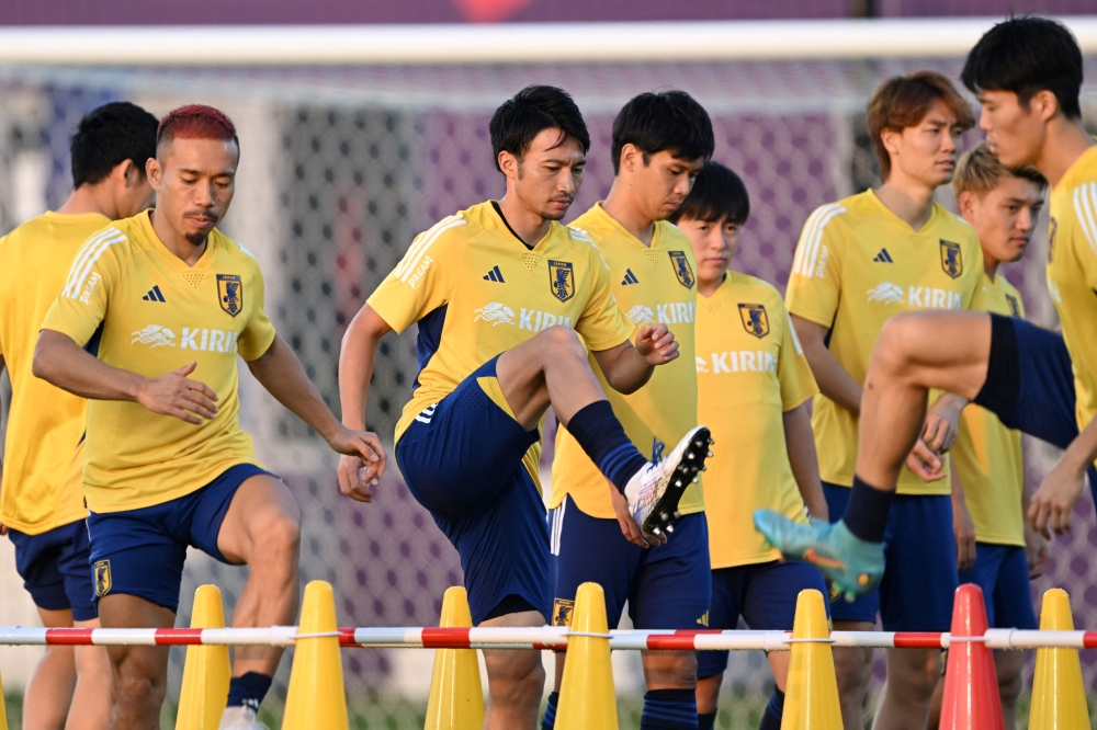 Japan's defender Yuto Nagatomo (left) and Japan's midfielder Gaku Shibasaki (centre) take part in a training session at the Al Sadd SC training grounds in Doha on December 3, 2022, during the Qatar 2022 World Cup football tournament. (Photo by INA FASSBENDER / AFP)