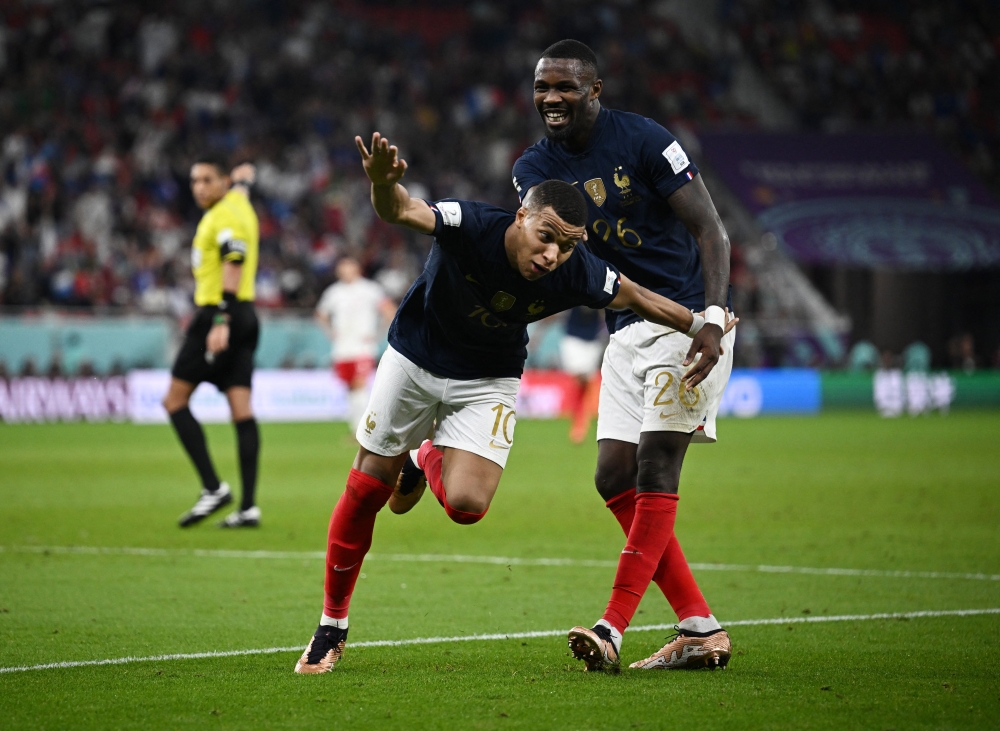 France's Kylian Mbappe celebrates scoring their third goal with Marcus Thuram during the FIFA World Cup Qatar 2022 Round of 16 match against Poland at the Al Thumama Stadium, Doha, Qatar, on December 4, 2022.  REUTERS/Dylan Martinez