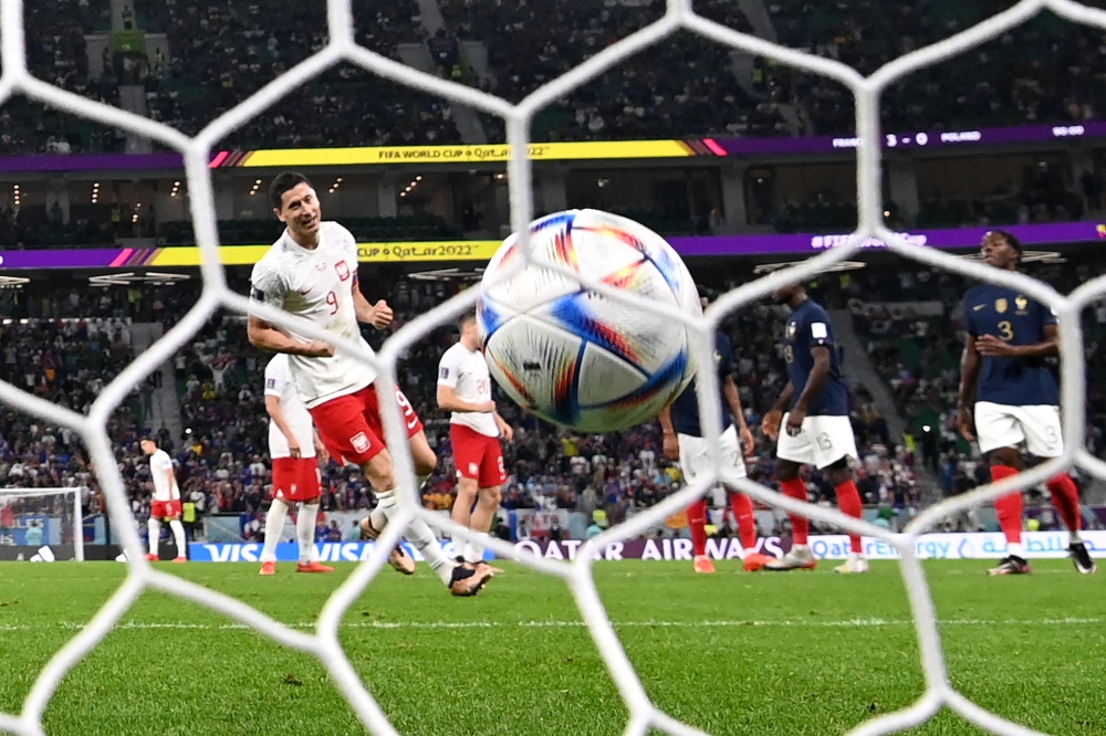 Poland's Robert Lewandowski scores his team's first goal after the penalty had to be retaken during the Qatar 2022 World Cup round of 16 football match between France and Poland at the Al Thumama Stadium in Doha on December 4, 2022. (AFP / Kirill Kudryavtsev)