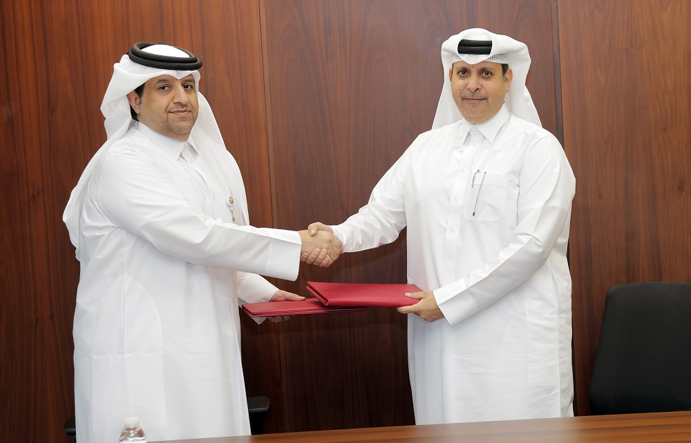 Acting Assistant Undersecretary for Shared Services Affairs at MoEHE, Ali Abdullah Al Buainain and CEO of WISA Abdulhadi Bakhit Burgan exchanging documents after singing the agreement.