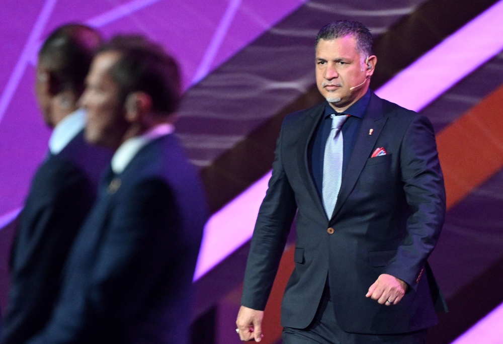 In this file photo taken on April 1, 2022, former Iranian footballer Ali Daei (right) arrives on stage during the draw for the 2022 World Cup in Qatar at the Doha Exhibition and Convention Center.(Photo by GABRIEL BOUYS / AFP)