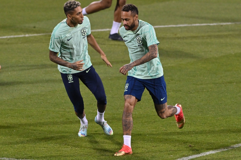 Brazil's forward Raphinha (left) and Neymar take part in a training session at the Al Arabi SC Stadium in Doha on December 4, 2022, on the eve of the Qatar 2022 World Cup football match between Brazil and South Korea. (Photo by NELSON ALMEIDA / AFP)
 