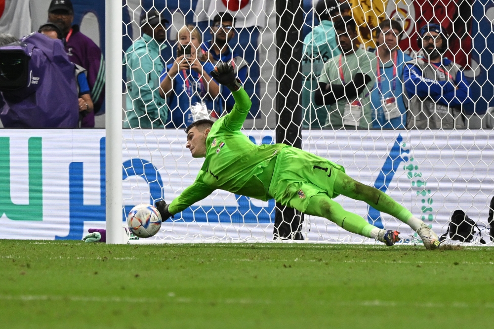 Croatia's goalkeeper Dominik Livakovic saves a shot during the Qatar 2022 World Cup round of 16 football match between Japan and Croatia at the Al-Janoub Stadium in Al-Wakrah, south of Doha on December 5, 2022. (Photo by ANDREJ ISAKOVIC / AFP)