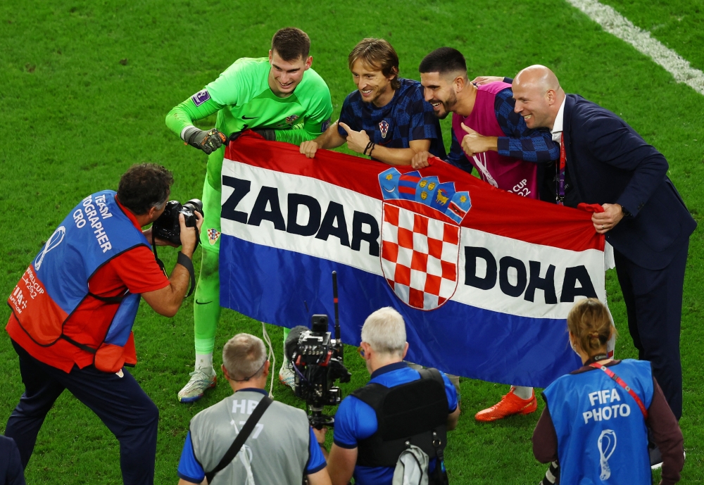 Croatia's Dominik Livakovic celebrates with Luka Modric after winning the penalty shootout as Croatia progress to the quarter finals of the FIFA World Cup Qatar 2022 at the Al Janoub Stadium, Al Wakrah, Qatar, on December 5, 2022.  REUTERS/Lee Smith