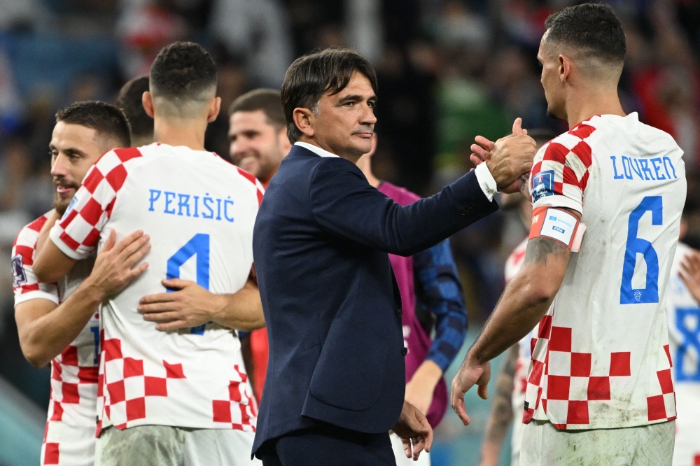 Croatia's coach #00 Zlatko Dalic (C) congratulates Croatia's defender #06 Dejan Lovren for their win in the Qatar 2022 World Cup round of 16 football match between Japan and Croatia at the Al-Janoub Stadium in Al-Wakrah, south of Doha on December 5, 2022. (Photo by Ina Fassbender / AFP)