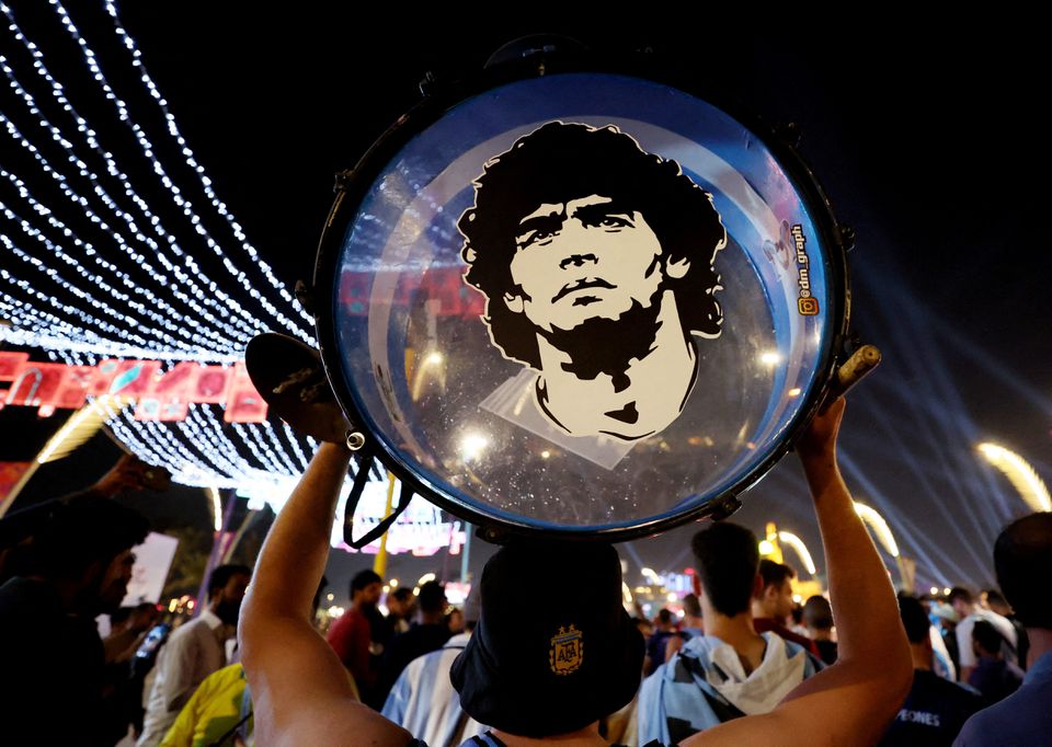 An Argentina fan holds up his drum showing an image of former player Diego Maradona on the Doha Corniche in Doha, Qatar, on November 25, 2022.  File Photo/Reuters