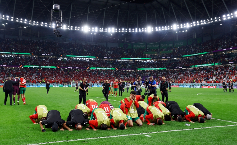 Morocco players and coaching celebrate winning the penalty shootout as Morocco progress to the quarter finals of the FIFA World Cup Qatar 2022 at the Education City Stadium, Al Rayyan, Qatar, on December 6, 2022.  REUTERS/Matthew Childs