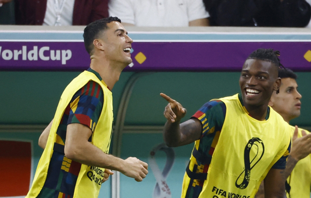 Portugal's Cristiano Ronaldo and Rafael Leao celebrate after Pepe scores their second goal as they watch from the substitutes bench REUTERS/Suhaib Salem