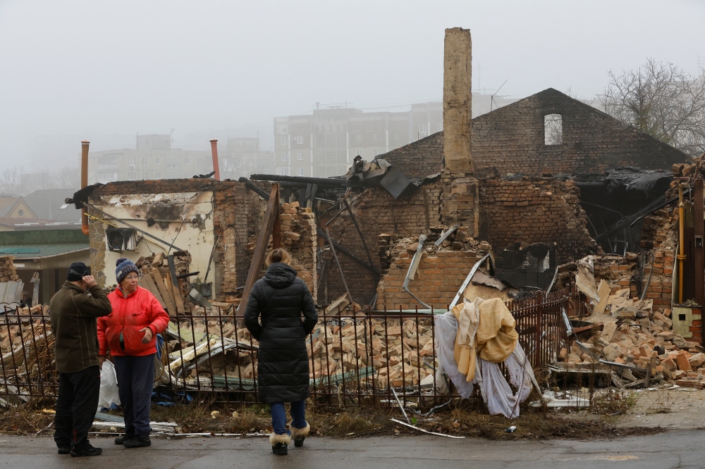 People gather near a residential building destroyed in recent shelling in the course of Russia-Ukraine conflict in Donetsk, Russian-controlled Ukraine, on December 10, 2022. REUTERS/Alexander Ermochenko