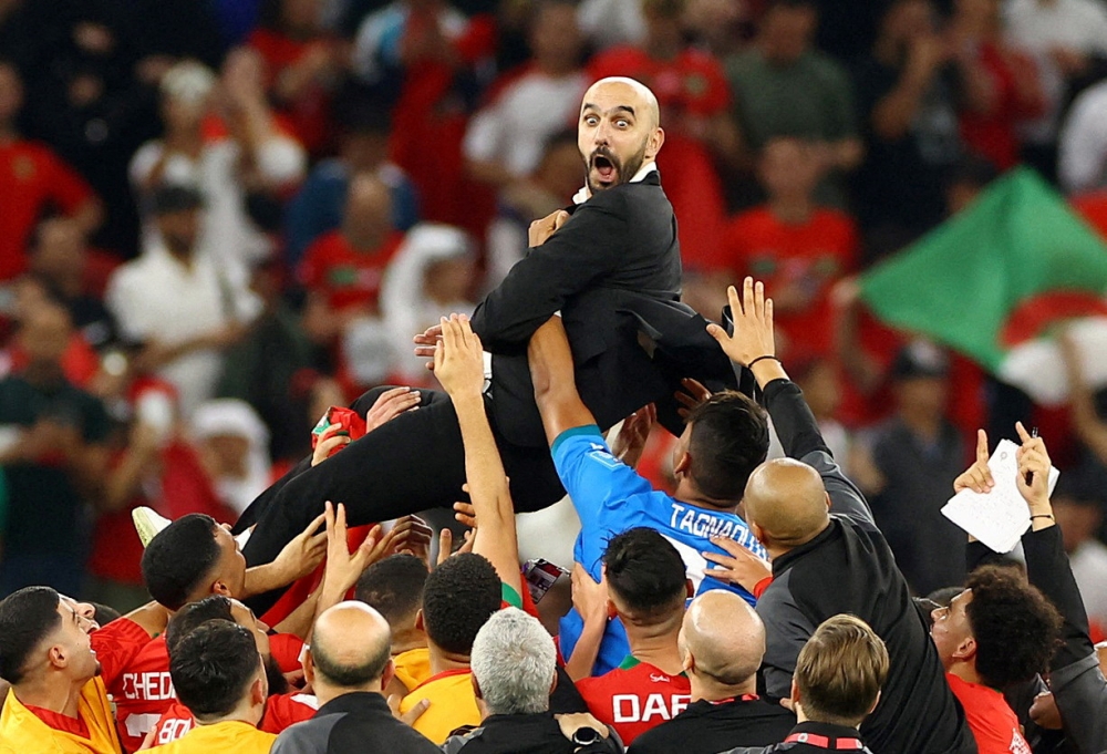 Morocco coach Walid Regragui celebrates with the players after the match as Morocco progress to the semi finals of the FIFA World Cup Qatar 2022 at the Al Thumama Stadium in Doha on December 10, 2022.  REUTERS/Bernadett Szabo 