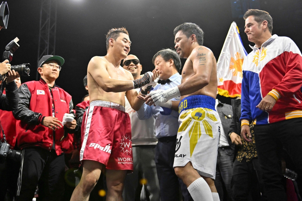 Manny Pacquiao (centre R) of the Philippines and DK Yoo (centre L) of South Korea react after their exhibition boxing match in Goyang, northwest of Seoul, on December 11, 2022. (Photo by Jung Yeon-je / AFP)