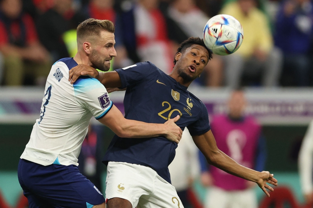 France's Kingsley Coman fights for the ball with England's Luke Shaw during the Qatar 2022 World Cup quarter-final match between England and France at the Al Bayt Stadium on December 10, 2022. (Photo by Adrian Dennis / AFP)