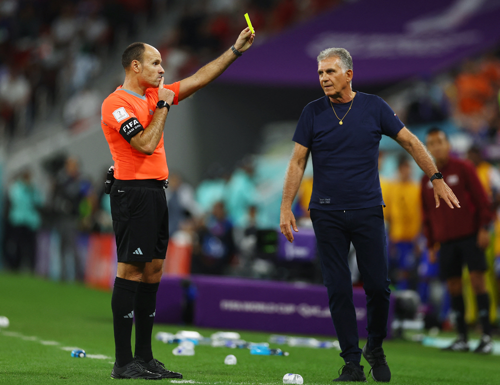 Referee Antonio Mateu Lahoz shows a yellow-card to Iran coach Carlos Queiroz (not in picture) during their World Cup Group B match against the USA. REUTERS