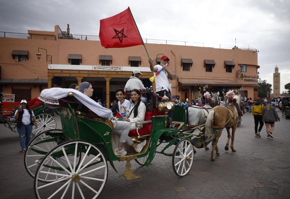 A man on a horse drawn carriage waves a Morocco flag in Marrakech ahead of the France versus Morocco semi-final match on December 14, 2022.  REUTERS/Juan Medina
 