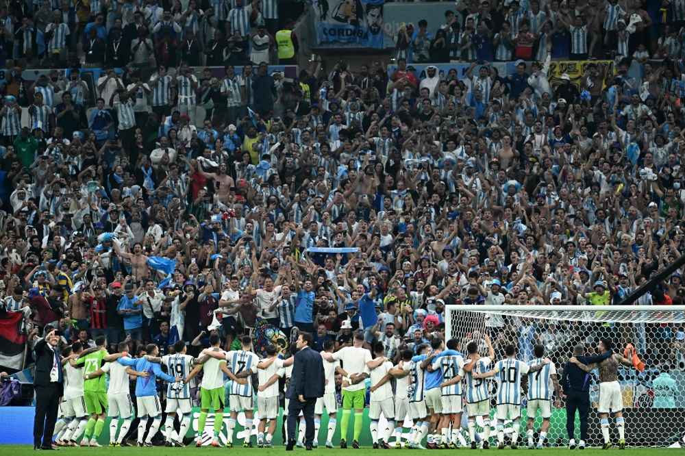 Argentina's players celebrate with supporters after defeating Croatia 3-0 in the Qatar 2022 World Cup football semi-final match between Argentina and Croatia at Lusail Stadium in Lusail, north of Doha on December 13, 2022. (Photo by Jewel SAMAD / AFP)