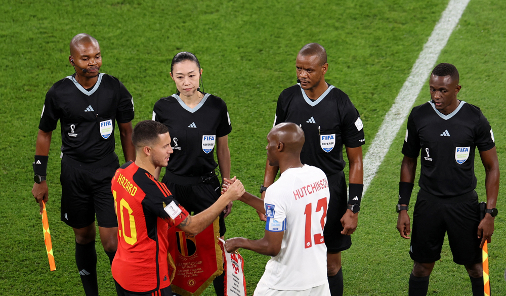 Fourth official Yoshimi Yamashita (second left) looks on with other officials as Belgium’s Eden Hazard shakes hands with Canada’s Atiba Hutchinson before the start of their World Cup Group F match at Ahmad Bin Ali Stadium. REUTERS