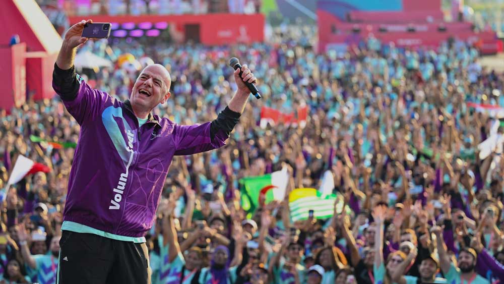 FIFA President Gianni Infantino taking a selfie with Qatar 2022 volunteers in the background during the Volunteer Celebration event.