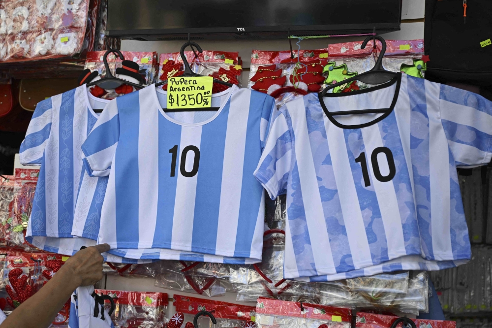 View of t-shirts of the Argentine national football team at a store in the eve of the Qatar 2022 World Cup final match between Argentina and France in Buenos Aires, on December 16, 2022. (Photo by Luis ROBAYO / AFP)