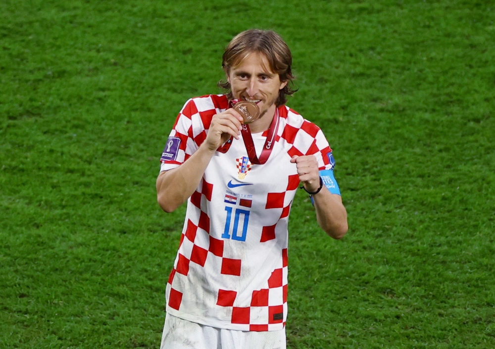 December 17, 2022 Croatia's Luka Modric bites his medal as he celebrates Croatia finishing in third place REUTERS/Kai Pfaffenbach