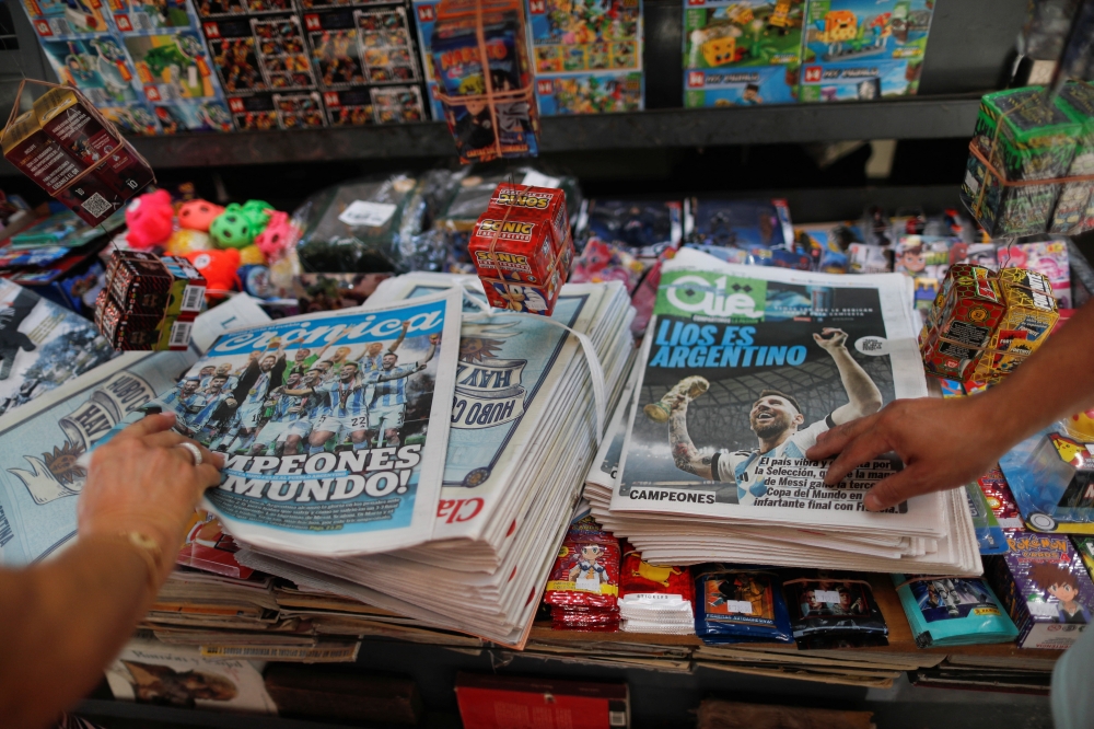 A picture of newspapers at a newstand with images of Argentina's Lionel Messi celebrating with the trophy after winning the FIFA World Cup Qatar 2022 in the front page, in Buenos Aires, Argentina on December 19, 2022. REUTERS/Agustin Marcarian