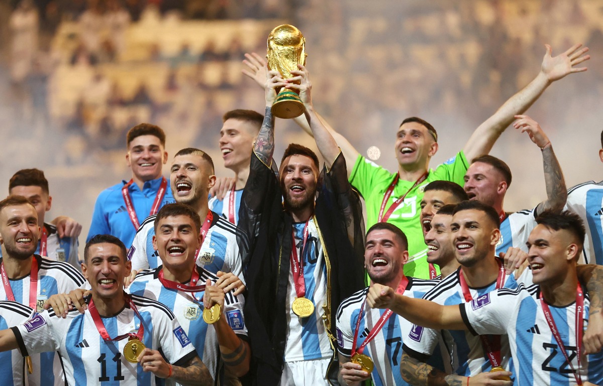 Argentina’s captain Lionel Messi lifts the World Cup trophy alongside teammates at Lusail Stadium on Sunday. REUTERS