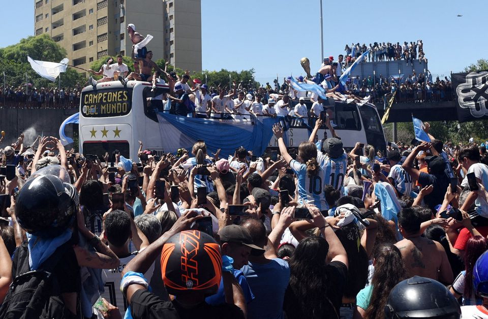 Argentina fans celebrate as the the bus carrying the players and the World Cup trophy is seen during the victory parade in Buenos Aires on December 20, 2022.  REUTERS/Martin Villar