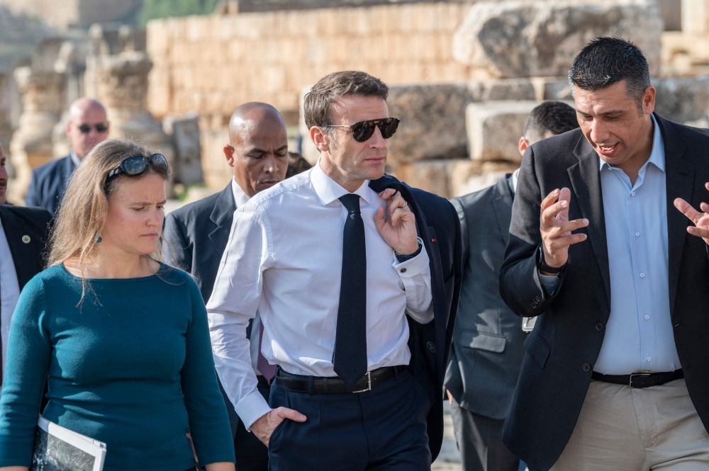 French President Emmanuel Macron (centre) visits the archaeological site of Jerash, Jordan on December 21, 2022.  (Photo by Eliot BLONDET / POOL / AFP)