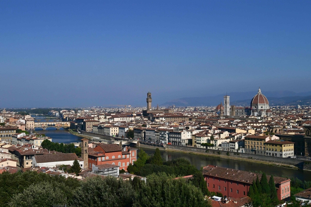 This file photo taken on September 14, 2020 taken from the heights of the city shows a general view of Florence with the Arno river, the oldo bridge, the Palazzo Vecchio (C), the Giotto bell tower and the Santa Maria del Fiore Cathedral or Duomo (R) in the center of Florence. (Photo by MIGUEL MEDINA / AFP)
 