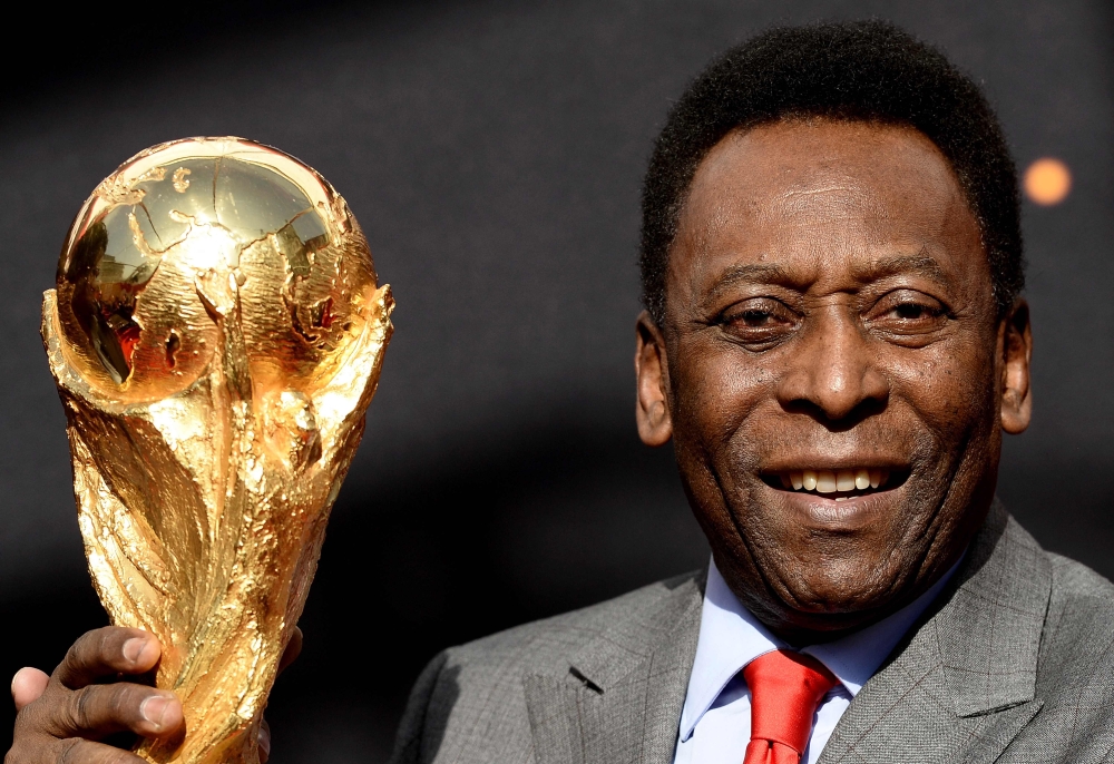 In this file photo taken on March 09, 2014, Brazilian football legend Pele poses with the FIFA World Cup trophy during a press conference, outside the Hotel de Ville in Paris. (Photo by Franck Fife / AFP)