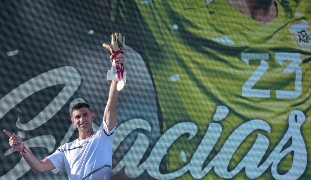 The goalkeeper of the Argentine soccer team Emiliano Martinez, holds gold medal and gold glove trophy awarded by FIFA during a tribute to him, in Mar del Plata, Argentina, on December 22, 2022, upon his return to his hometown after winning the Qatar 2022 World Cup tournament. (Photo by Mara SOSTI / AFP)