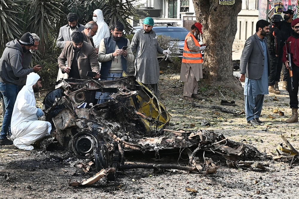 Police officers collect evidence at the site of a suicide car bombing in Islamabad, Pakistan, December 23, 2022. (REUTERS/Waseem Khan)

