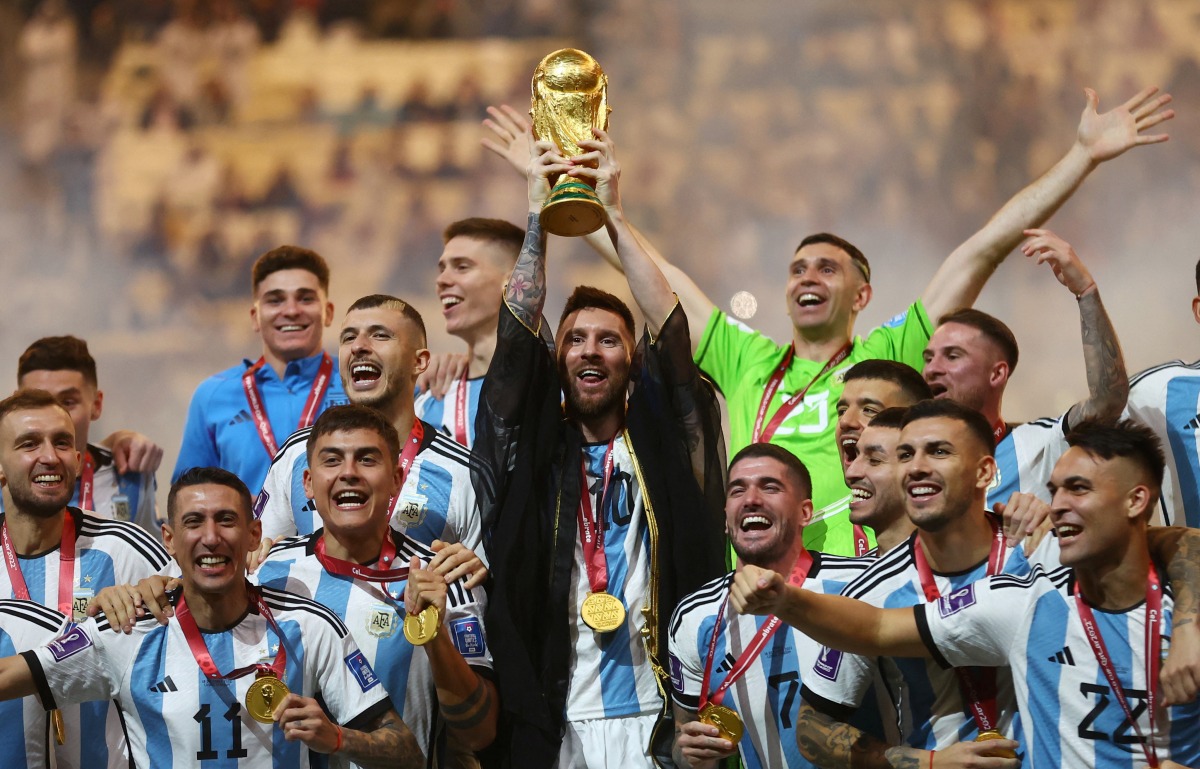 Argentina's Lionel Messi lifts the World Cup trophy alongside teammates as they celebrate winning the FIFA World Cup Qatar 2022 at the Lusail Stadium in Lusail on December 18, 2022. REUTERS/Carl Recine 

