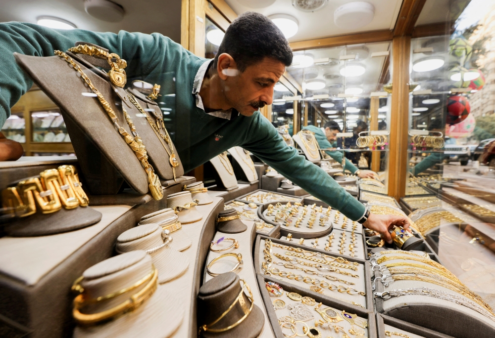 A gold vendor sorts jewellery pieces inside a shop at the gold market area, as gold prices recorded an increase after the latest devaluation of the local currency in Cairo, Egypt, December 8, 2022. (REUTERS/Mohamed Abd El Ghany)