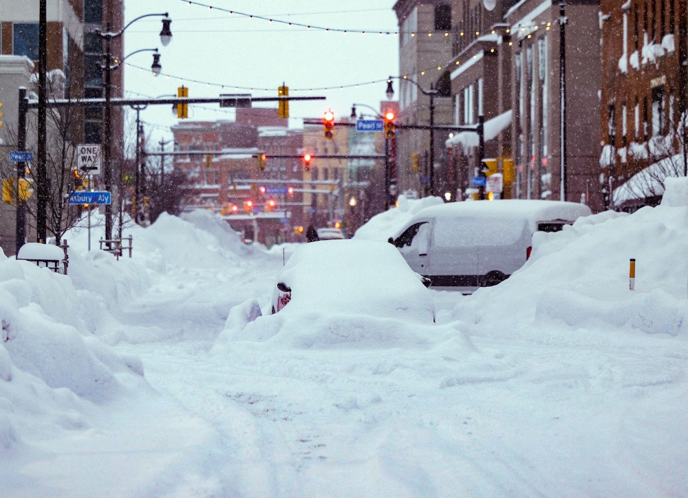 In this handout photo from the Office of Governor Kathy Hochul, vehicles are seen trapped under heavy snow in the streets of downtown Buffalo, New York, on December 26, 2022. (Photo by THE OFFICE OF GOVERNOR KATHY HOCHUL / AFP) 