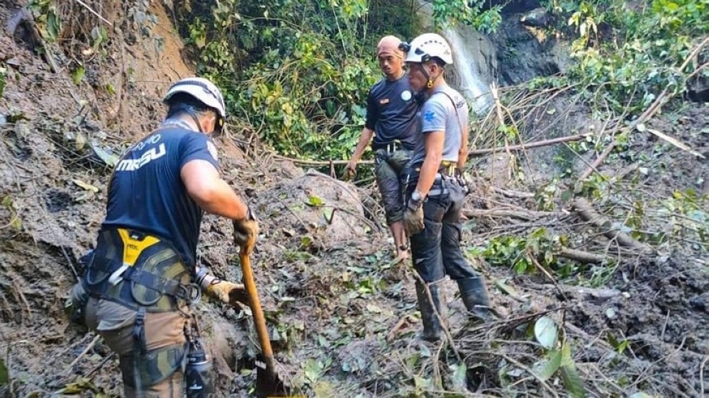 In this handout photo from Mati City Disaster Risk Reduction Management Office taken on December 29, 2022, shows rescuers searching for missing people following a landslide in Mati City, Davao Oriental. Photo by Handout / Mati City Disaster Risk Reduction Management Office / AFP