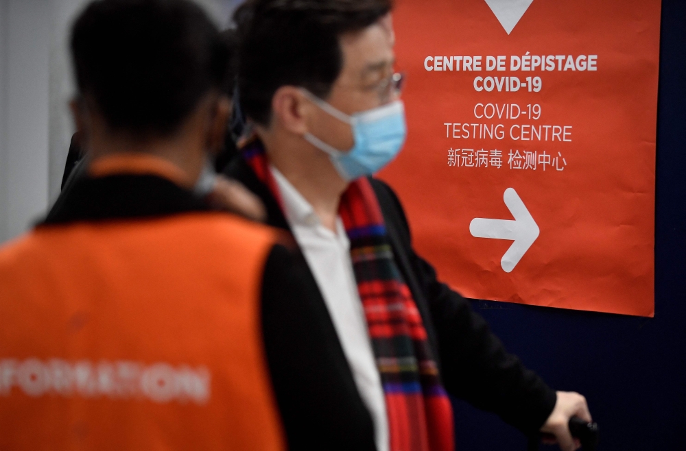 Travellers of a flight from China enter the COVID-19 testing centre of the Paris-Charles-de-Gaulle airport in Roissy, outside Paris, on January 1, 2023. (Photo by Julien De Rosa / AFP)