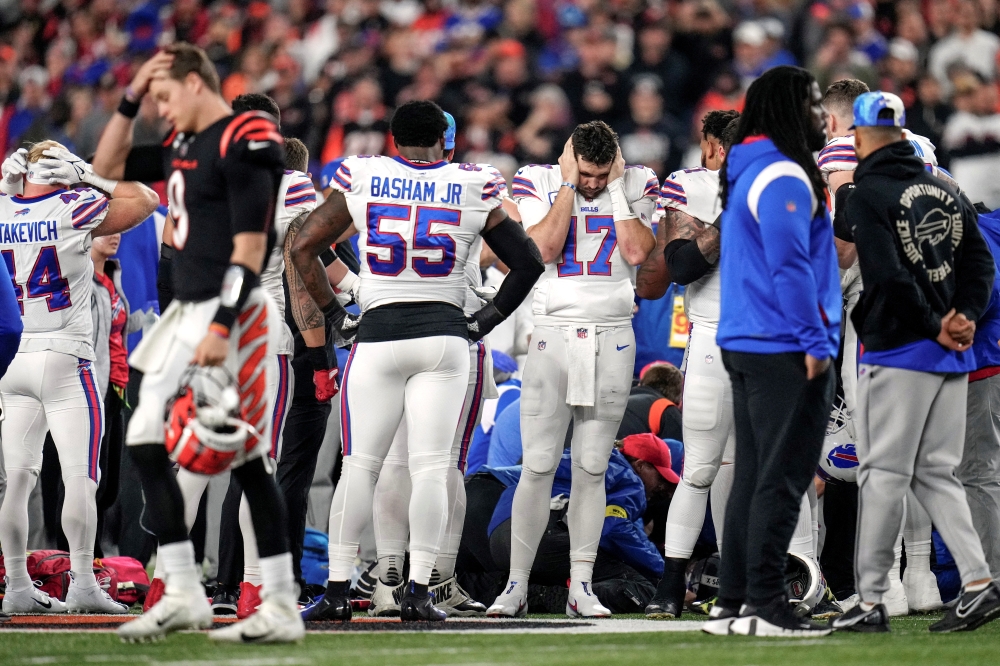 Cincinnati, Ohio, USA; The Buffalo Bills gather as an ambulance parks on the field while CPR is administered to Buffalo Bills safety Damar Hamlin (3) after a play in the first quarter of the NFL Week 17 game between the Cincinnati Bengals and the Buffalo Bills at Paycor Stadium in Downtown Cincinnati. Mandatory Credit: Sam Greene-USA TODAY Sports