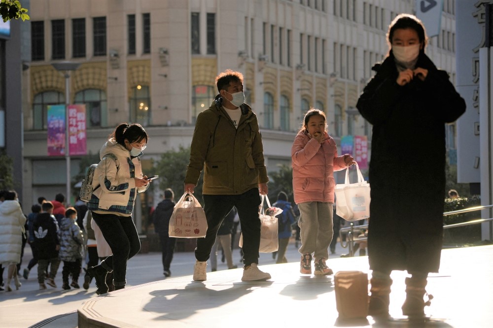 People wearing protective masks walk in a shopping district as China returns to work despite continuing coronavirus disease (COVID-19) outbreaks in Shanghai, China, January 3, 2023. (REUTERS/Aly Song)